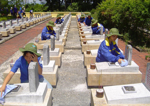 Sinh viên tình nguyện Đà Nẵng chăm sóc các phần mộ liệt sĩ tại Nghĩa trang Liệt sĩ Quốc gia Trường Sơn 2.  Ảnh: HOÀNG HIỆP