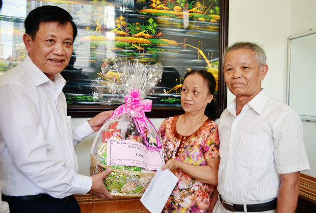 Bí thư Thành ủy, Chủ tịch HĐND thành phố Trần Thọ tặng quà gia đình thương binh Phan Thị Thông. Ảnh: VIỆT DŨNG