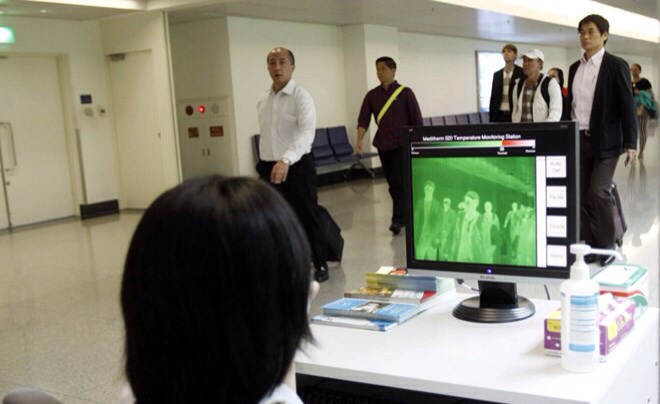 Nhân viên Trung tâm Kiểm dịch quốc tế giám sát thân nhiệt của hành khách qua máy đo ở sân bay Tân Sơn Nhất.