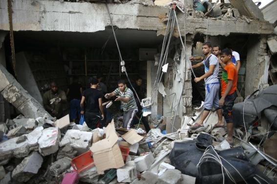 Người dân Palestin trước cảnh hoang tàn sau một đợt không kích của Israel nhằm vào Dải Gaza, ngày 21-8-2014. Ảnh: Reuters