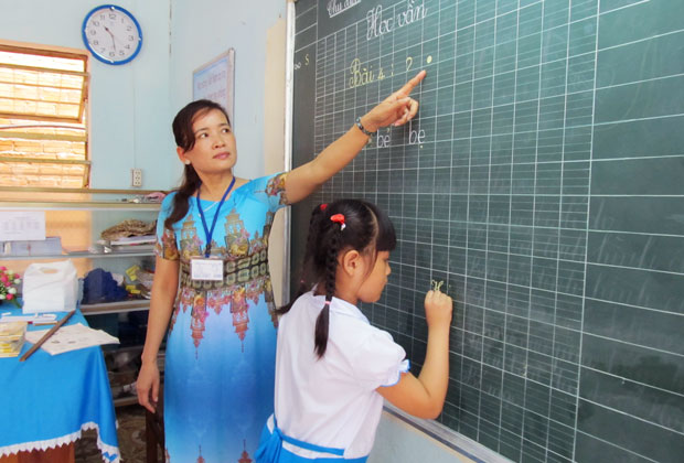 Giáo viên Trường tiểu học Nguyễn Văn Trỗi hướng dẫn học sinh đọc bài.