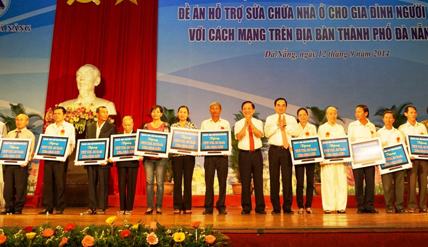 Bí thư Thành ủy, Chủ tịch HĐND thành phố Trần Thọ và Chủ tịch UBND thành phố Văn Hữu Chiến trao bảng tượng trưng tivi cho các hộ chính sách. 