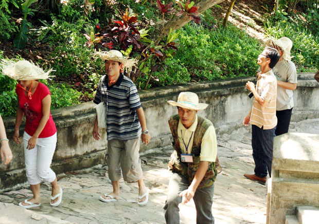 Anh Lê Văn Hòa (đeo thẻ) trong một lần đưa khách lên ngọn Thủy Sơn, khu danh thắng Ngũ Hành Sơn.