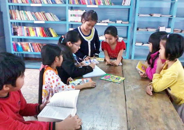 Các em thiếu nhi đọc sách, truyện tại phòng đọc sách tại thôn Quang Châu, xã Hòa Châu, huyện Hòa Vang.