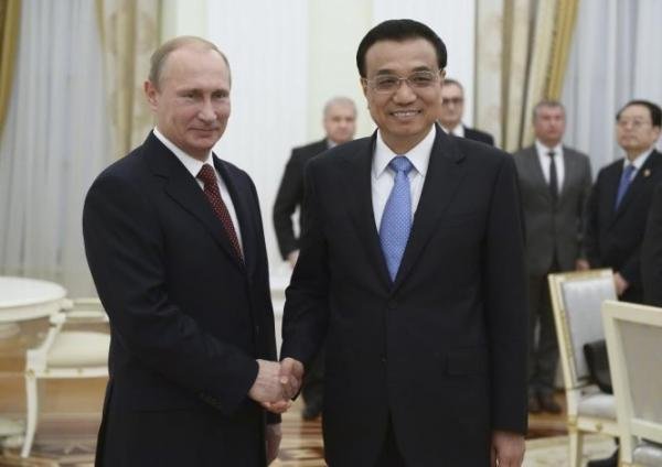 Tổng thống Nga Vladimir Putin bắt tay Thủ tướng Trung Quốc Lý Khắc Cường trong cuộc gặp ở Matxcơva - Ảnh: Reuters