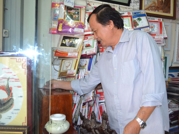 Ông Nguyễn Hồng Thịnh sử dụng chuông báo động không dây tại cửa hàng của mình.