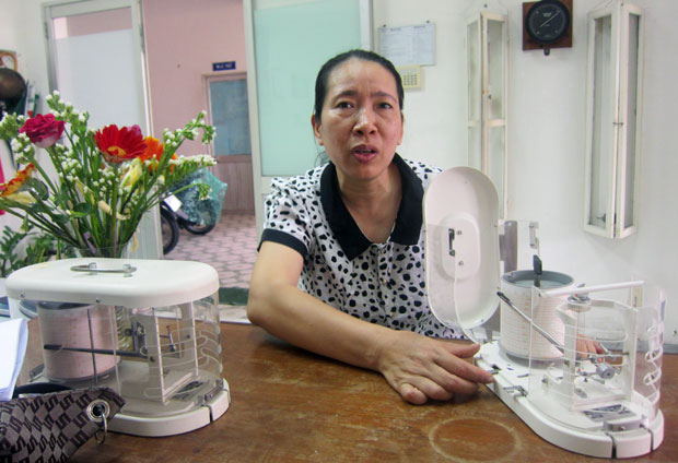 Chị Nguyễn Thị Hồng, Phó trưởng trạm Khí tượng Đà Nẵng và chiếc máy ẩm ký, một trong những máy móc hiện đại hỗ trợ công việc của người làm quan trắc khí tượng. Ảnh: H.N