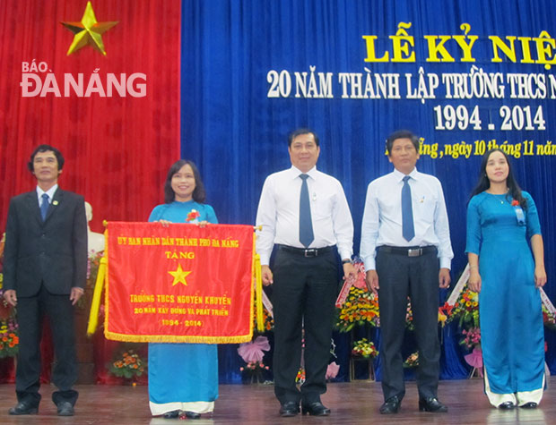 Phó Chủ tịch UBND thành phố Đà Nẵng Huỳnh Đức Thơ trao Cờ truyền thống của UBND thành phố tặng Trường THCS Nguyễn Khuyến. Ảnh: PHƯƠNG CHI