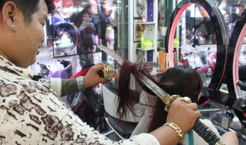 Vietnamese barber Nguyen Hoang Hung is pictured cutting and styling his client's hair with two Japanese Samurai swords.