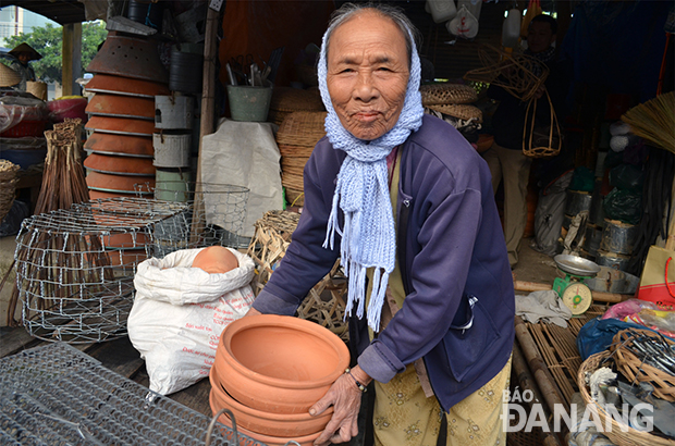 Bà Đỗ Thị Lượm (85 tuổi) bán rổ rá, lồng nhốt gà vịt bằng tre, ấm sắc thuốc, bếp nấu làm bằng đất tại chợ Túy Loan. Ảnh:M.T