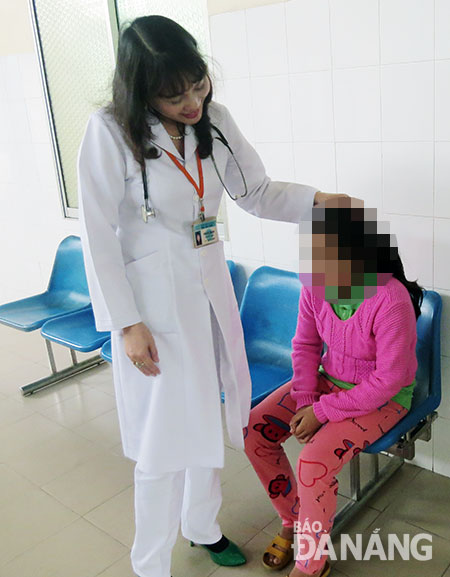 Bác sĩ Trần Thị Hải Vân, Trưởng khoa Tâm thần trẻ em, thăm hỏi một bệnh nhi.