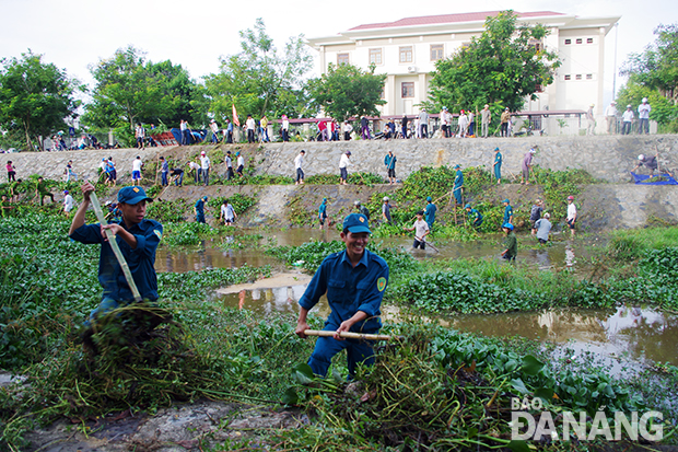 Lực lượng dân quân huyện Hòa Vang tham gia cùng các đoàn thể nạo vét kênh Túy Loan làm sạch môi trường.  						Ảnh: PHƯỚC VINH