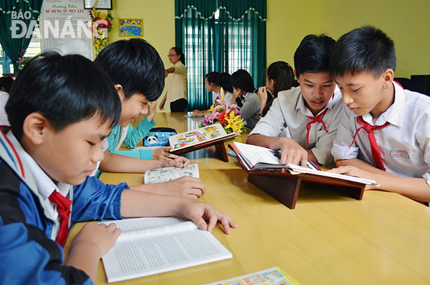 Các em học sinh Trường THCS Nguyễn Văn Linh tranh thủ đọc sách trong giờ ra chơi. Ảnh: M.T
