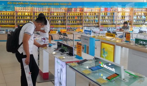 A man tests out an HTC smartphone at a mobile phone store in Ho Chi Minh City.