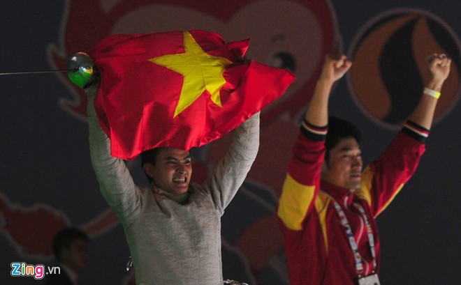 VĐV của Đoàn Thể thao Việt Nam giơ cao quốc kỳ ăn mừng chiến thắng ở SEA Games 28. 