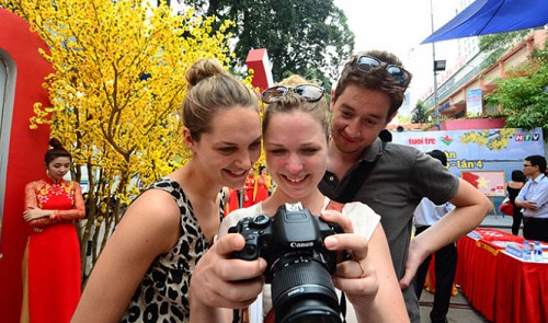 Foreign tourists view photos on their camera at an event in Ho Chi Minh City on January 23, 2015.