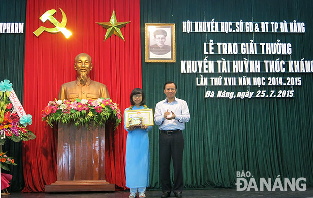 Phó Bí thư Thành ủy Nguyễn Xuân Anh trao giải thưởng Huỳnh Thúc Kháng cho học sinh xuất sắc. Ảnh: BẢO THIÊN