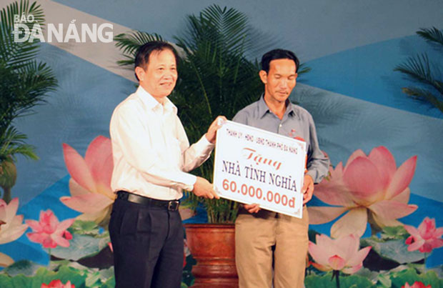Bí thư Thành ủy Trần Thọ trao tiền hỗ trợ 60 triệu đồng cho gia đình bệnh binh Nguyễn Thị Ân. 		        ảnh: PHƯƠNG TRÀ