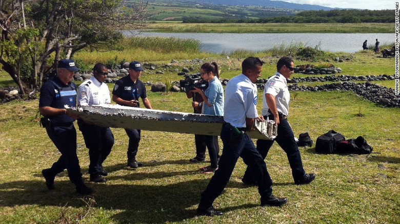 Cảnh sát đang thu giữ mảnh vỡ được nghi là từ máy bay MH370 được tìm thấy ngoài khơi Đảo Reunion, ngày 29-7-2015. Ảnh: Getty