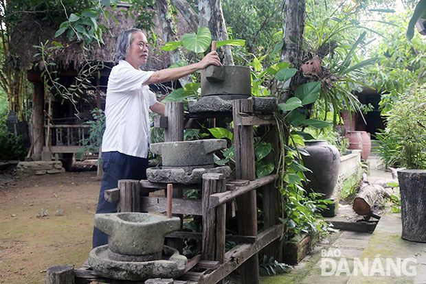 Ông Đỗ Hữu Minh và bộ sưu tập các loại cối xay đá trong vườn nhà cổ Tích Thiện Đường. Ảnh: V.T.L