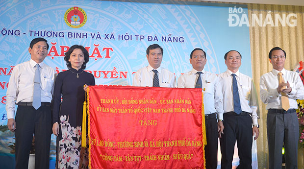 Phó Bí thư Thành ủy Nguyễn Xuân Anh trao bức trướng mang dòng chữ “Công tâm - Tận tụy - Trách nhiệm - Hiệu quả” cho Sở LĐ-TB&XH. Ảnh: Phương Trà
