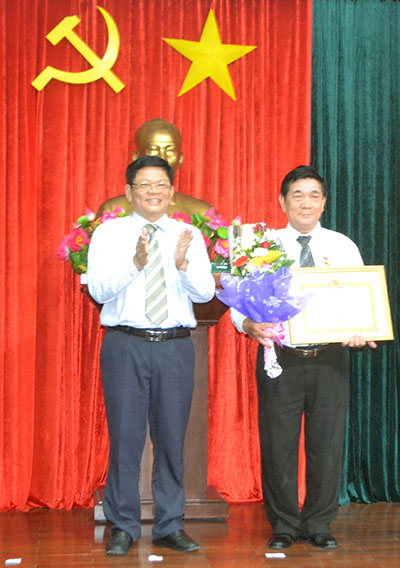 Phó Bí thư thường trực Thành ủy Võ Công Trí trao Huy hiệu 50 năm tuổi Đảng cho đảng viên Đoàn Hồng Chương. Ảnh: ĐOÀN LƯƠNG