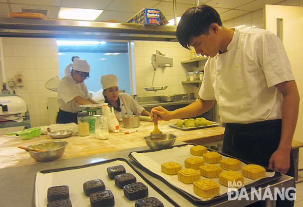 Những chiếc bánh Trung thu tự làm ở Furama Resort sau khi nướng lần 1 sẽ được “chải” thêm trứng cho chiếc bánh ánh màu vàng hổ phách.
