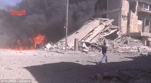 Các tòa nhà sụp đổ và đám cháy sau khi máy bay Nga không kích ở tỉnh Homs, miền Trung Syria, hôm 30-9. Ảnh: RT
