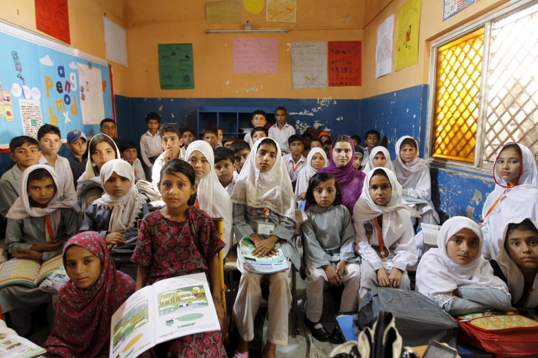 Học sinh lớp 3 ngồi chen chúc và không có bàn trong lớp học ở ngoại ô Islamabad (Pakistan).