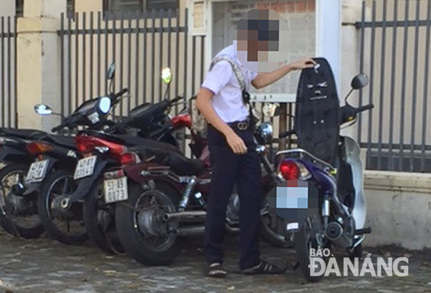 Một học sinh Trường THPT Trần Phú gửi xe máy ở điểm giữ xe vỉa hè, để vào trường.