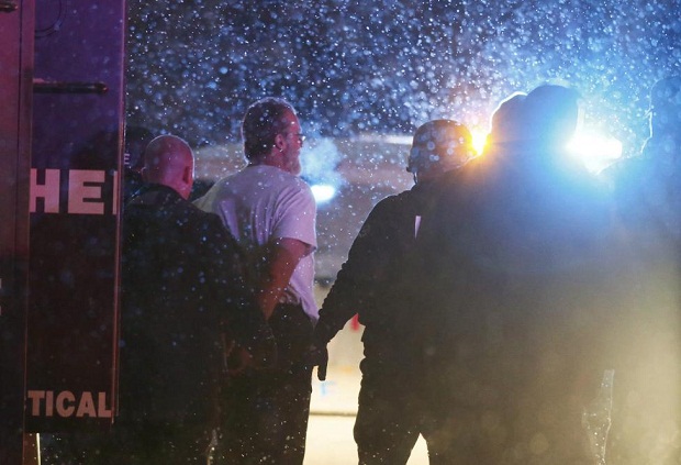 Một nghi phạm mặc áo thun trắng bị còng tay, sau khi cảnh sát thuyết phục y đầu hàng trong vụ xả súng tại bệnh viện Kế hoạch hóa sinh sản Colorado Springs, ngày 27-11-2015 tại bang Colorado, Mỹ.