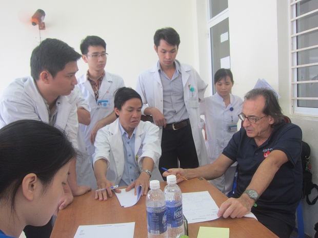 GS.BS Roberto DeCastro (bìa phải) trao đổi chuyên môn trước giờ phẫu thuật với các y, bác sĩ khoa Ngoại Nhi, BV Phụ sản -Nhi Đà Nẵng sáng 29-11.