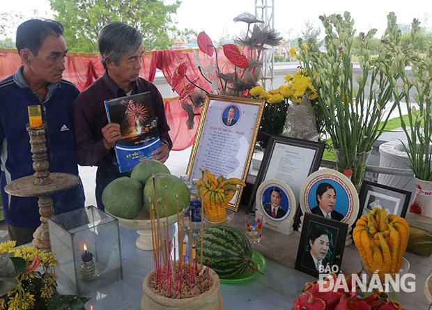 Ông Huỳnh Tâm gửi tặng cuốn sách tâm huyết của mình cho khu mộ ông Nguyễn Bá Thanh. Ảnh: V.T.L