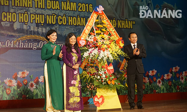 Bí thư Thành ủy Nguyễn Xuân Anh tặng hoa chúc mừng Hội LHPN nhân Ngày Quốc tế Phụ nữ 8-3.  Ảnh: BÌNH AN