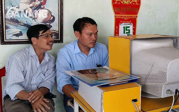 Anh Đặng Ngọc Hải (phải) đang làm việc tại tiệm xử lý ảnh của mình. Ảnh: T.T