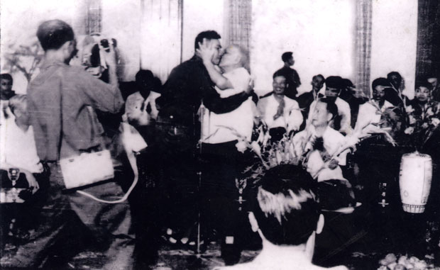 Ông Bùi Văn Tùng (áo sẫm, giữa) được thay mặt quân đội nhận nụ hôn khen ngợi của Chủ tịch nước Tôn Đức Thắng tại buổi bình công 5 cánh quân giải phóng Sài Gòn tổ chức ngày 16-5-1975 tại dinh Độc Lập. (Ảnh tư liệu do gia đình ông Tùng cung cấp).