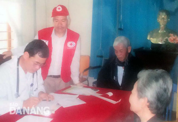 Ông Bùi Xuân Mạnh, Chủ tịch Hội Chữ thập đỏ phường Thuận Phước (đứng), tham gia hoạt động tình nguyện phối hợp khám chữa bệnh cho người nghèo.