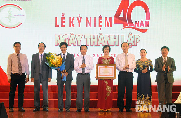 Bí thư Thành ủy Nguyễn Xuân Anh (thứ 4 từ trái sang) và Thứ trưởng Bộ Y tế Lê Quang Cường (thứ 3 từ phải sang) trao Bằng khen của Thủ tướng Chính phủ cho tập thể Bệnh viện C Đà Nẵng.