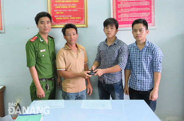 Sinh viên Phạm Hoàng Thương và Nguyễn Trung Thảo (bìa phải) trao chiếc ví lại cho anh Nguyễn Đình Luật. 