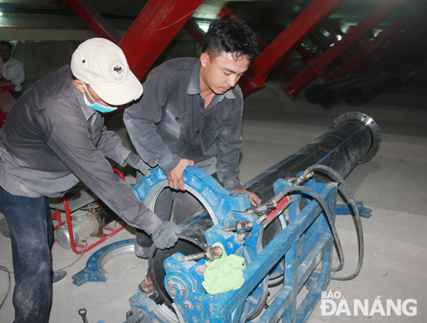 Trong lòng cầu Trần Thị Lý, các công nhân đang nỗ lực thi công đường ống cấp nước bổ sung nước sinh hoạt cho hai quận Sơn Trà, Ngũ Hành Sơn.     		Ảnh: HOÀNG HIỆP