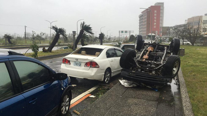 Một chiếc ô tô bị cơn bão “lật ngửa” trên đường phố Đài Trung, Đài Loan sáng 8/7. (Ảnh: weather