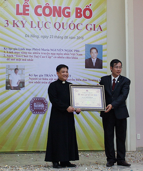 Linh mục Nguyễn Ngọc Phi nhận Bằng chứng nhận xác lập kỷ lục quốc gia từ đại diện Vietkings.  Ảnh: SƠN TRUNG