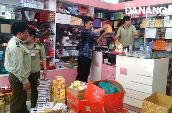 Lực lượng quản lý thị trường kiểm đếm số lượng sản phẩm mỹ phẩm, thực phẩm chức năng tại nhà 208 Tôn Đản. Ảnh: DUYÊN ANH