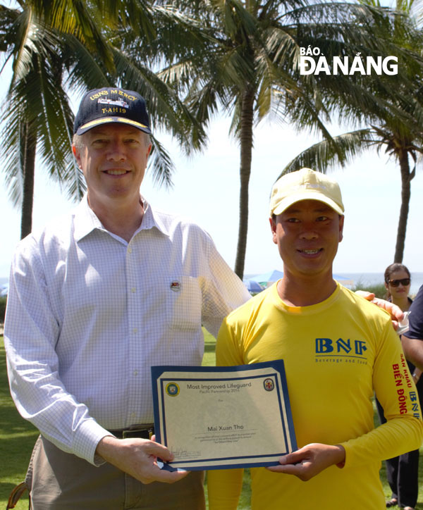 Đại sứ Hoa Kỳ tại Việt Nam Ted Osius trao giấy khen cho ông Mai Xuân Thọ sau khóa tập huấn về bảo vệ tính mạng. Ảnh: KHANG NINH
