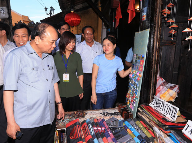 Thủ tướng Nguyễn Xuân Phúc thăm các gian hàng tại khu du lịch phố cổ Hội An.            				             Ảnh: TTXVN