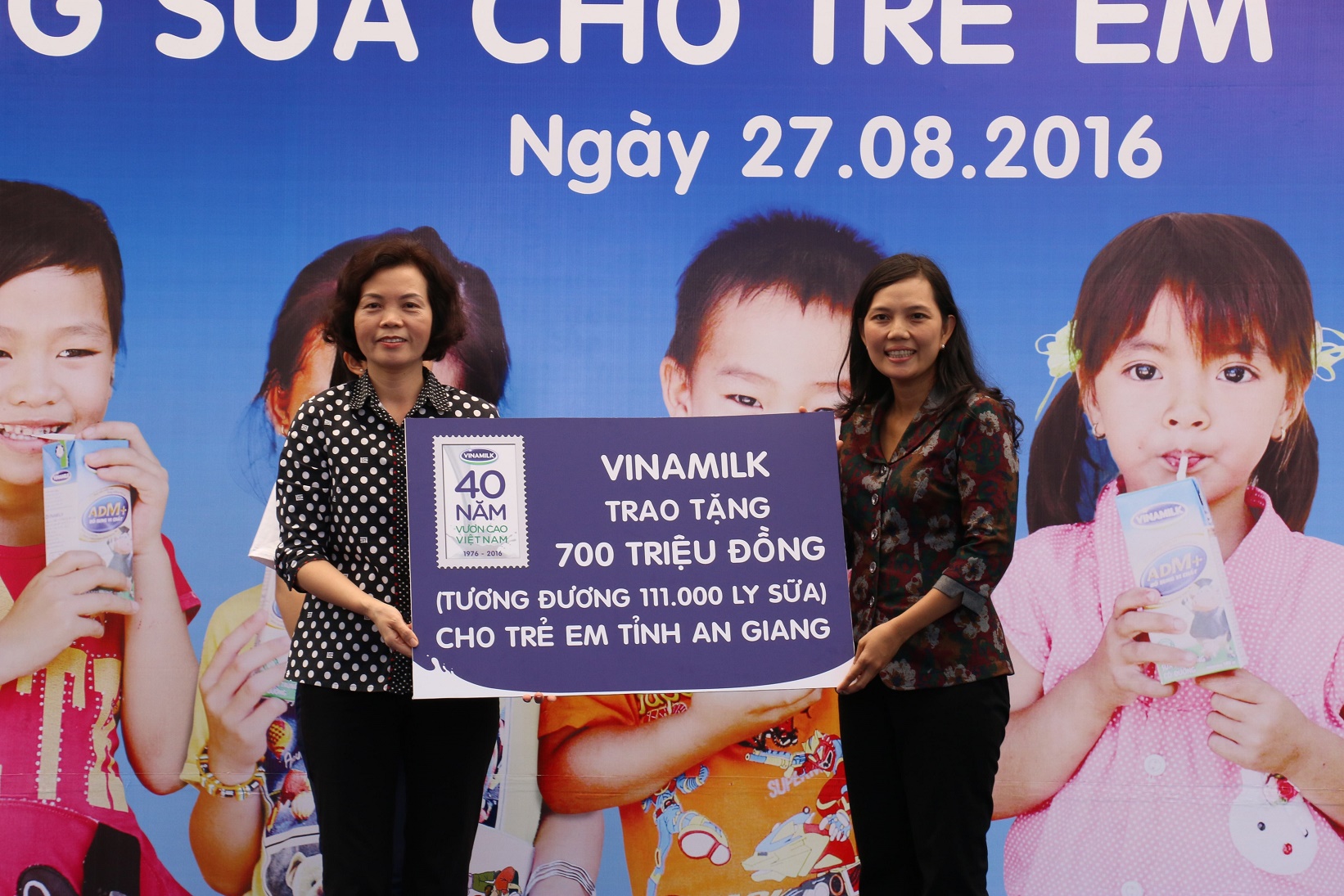 Bà Bùi Thị Hương, Giám đốc Điều hành Vinamilk trao tặng bảng tượng trưng 700 triệu đồng, tương đương 111.000 ly sữa của Quỹ Sữa Vươn cao Việt Nam cho trẻ em nghèo tỉnh An Giang. Ảnh: Dũng Phương