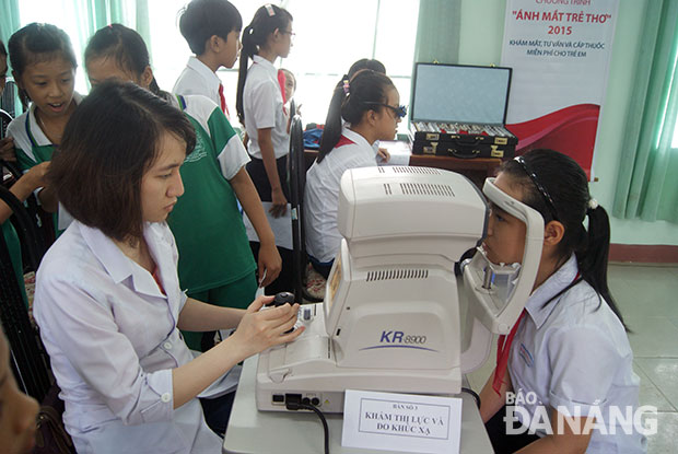 Khám mắt cho học sinh ở xã Hòa Nhơn trong chương trình “Vì ánh mắt trẻ thơ” năm 2015. Ảnh: H.L