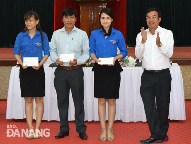 Chủ tịch UBND quận Liên Chiểu Đàm Quang Hưng (phải) khen thưởng 3 đoàn viên có sáng kiến hay về cải cách hành chính tại buổi đối thoại.