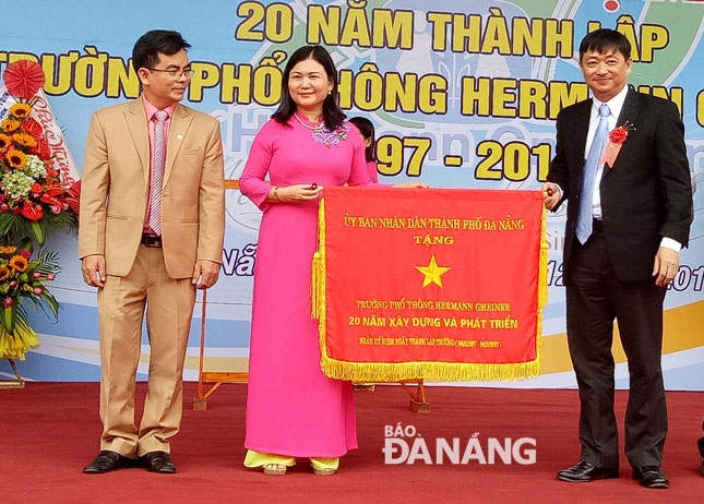 Phó Chủ tịch UBND thành phố Đặng Việt Dũng trao bức trướng của UBND thành phố ghi nhận những đóng góp trong 20 năm xây dựng và phát triển của nhà trường.