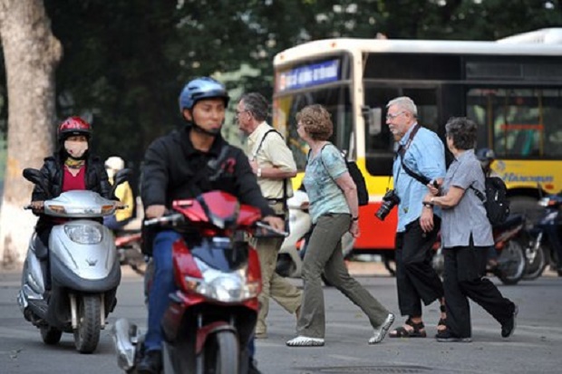 Foreign tourists acrossing a street in Viet Nam. Photo by VnExpress